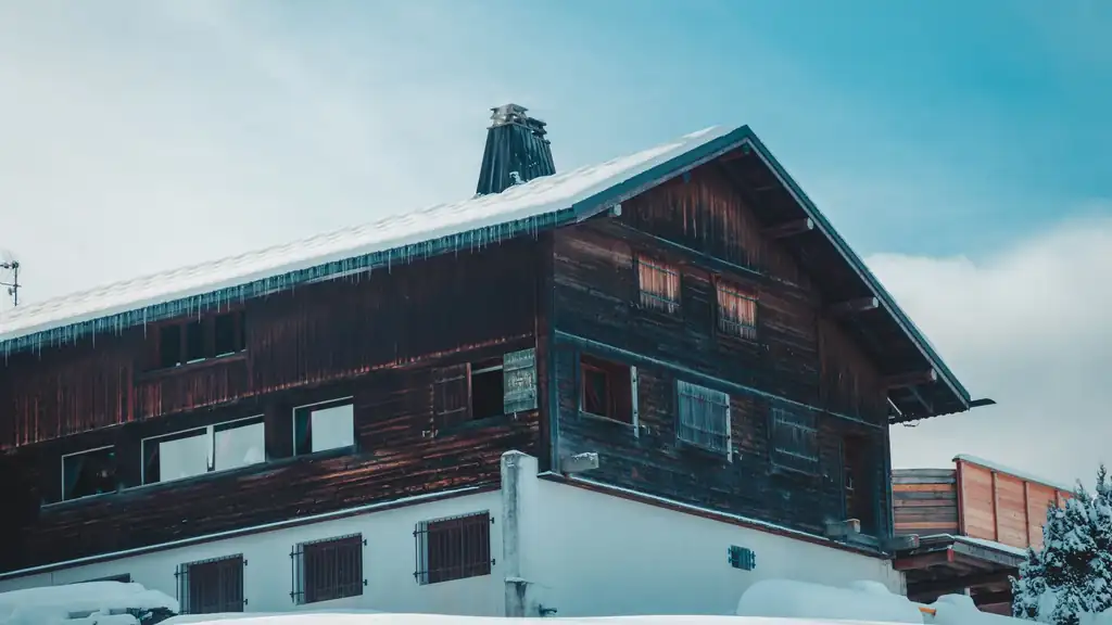 Wooden alpine chalet blanketed in deep snow